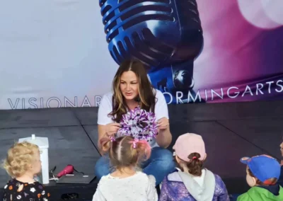 Author showing craft item to a group of kids.