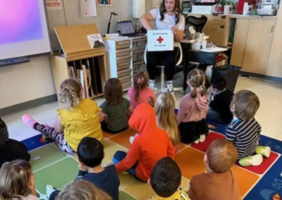 Teacher showing first aid kit to a group of kids.